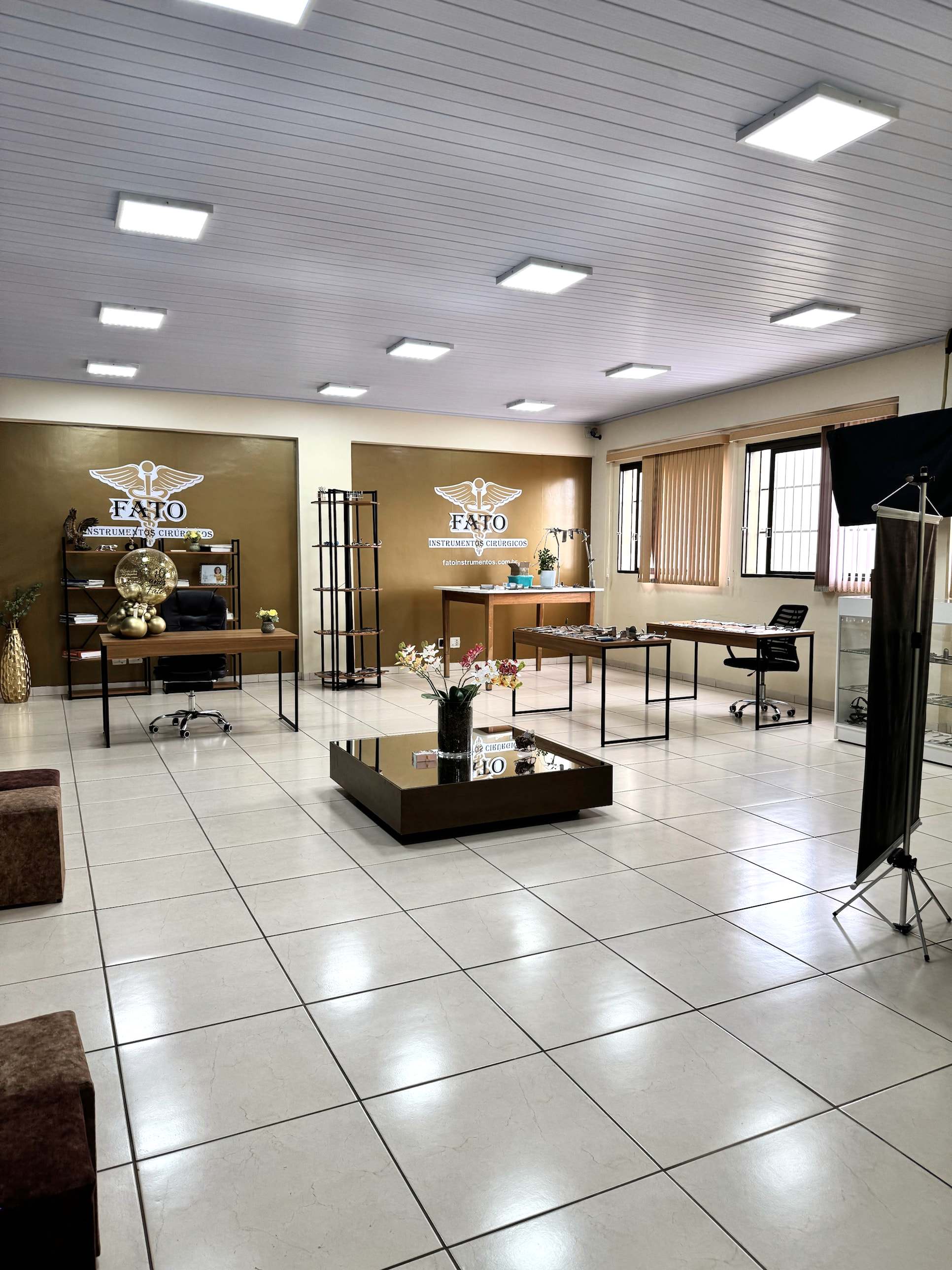 Vista geral do showroom da FATO em Ribeirão Preto, com duas paredes com a logo e mesas de atendimento.