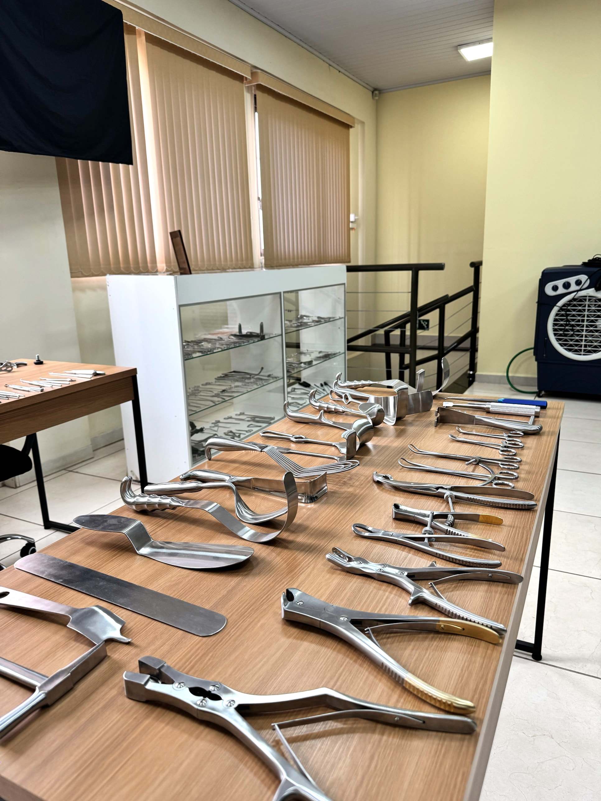 Mesa do showroom com afastadores, serras e pinças de grande porte expostos lado a lado.